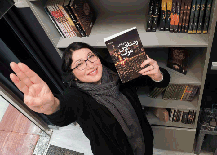 Zoha Kazemi holding her award winning book "Death Renaissance"